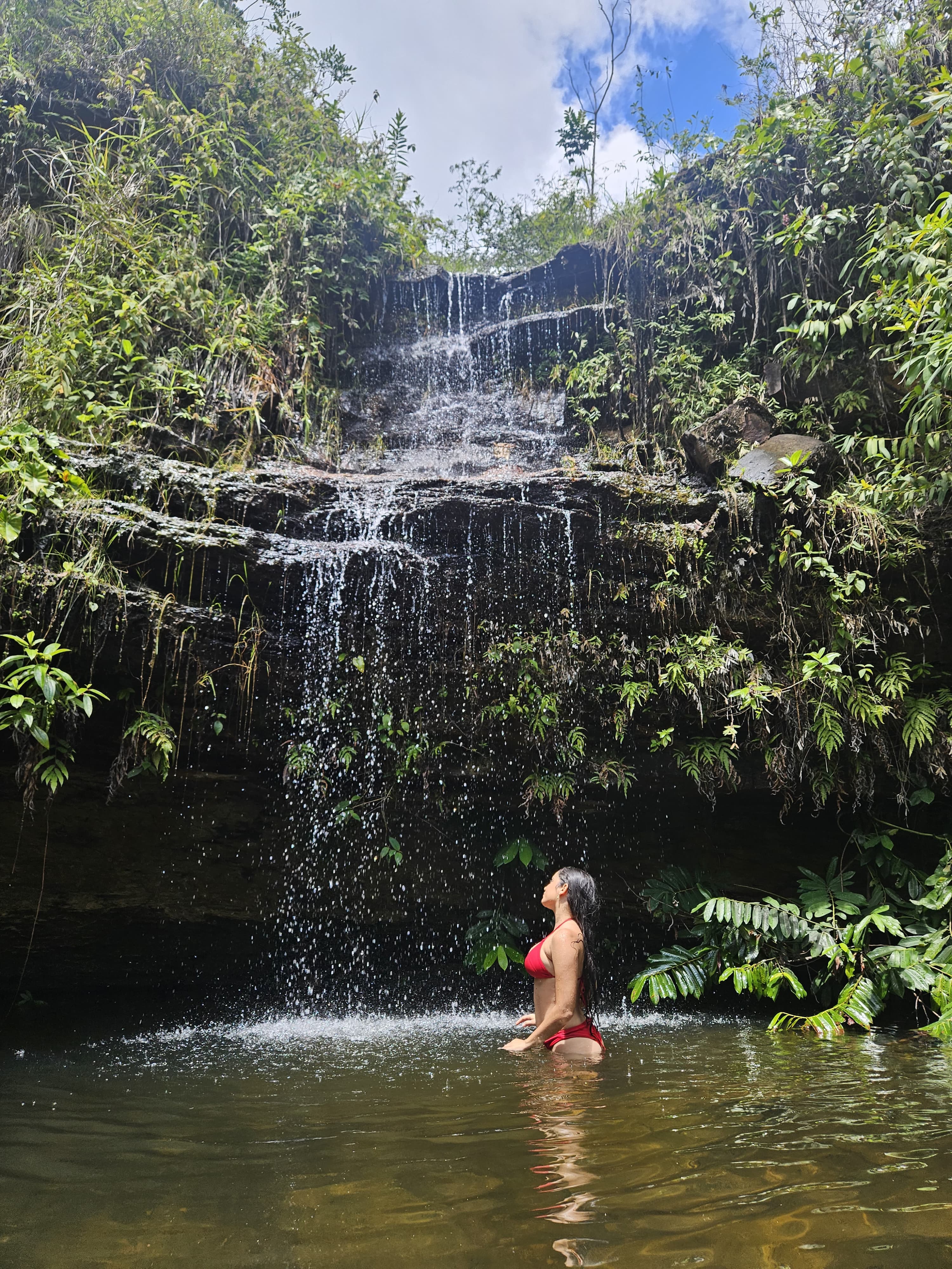 ajoelhada embaixo da queda d’água