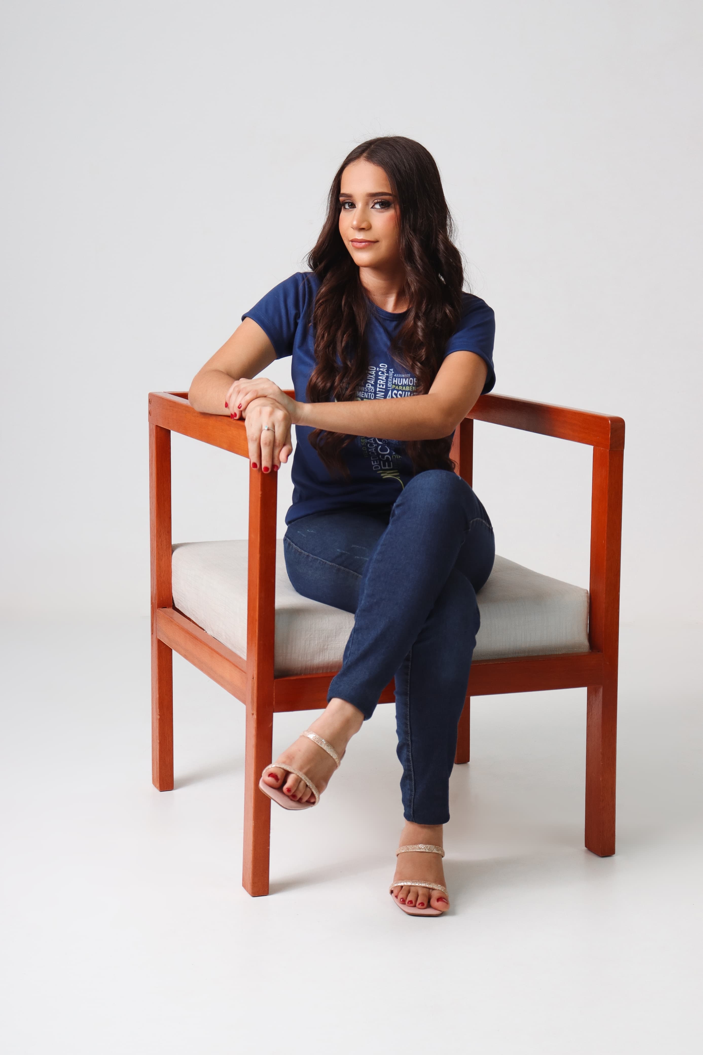 sentada em cadeira de madeira, pose de estúdio